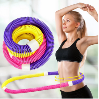 Colorful sport hoop fitness equipment, lightweight and flexible for home workout, woman exercising with hoop in sportswear.