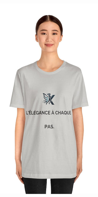 Elegant gray women's t-shirt with French text and graphic design, showcased by a smiling model against a white background.