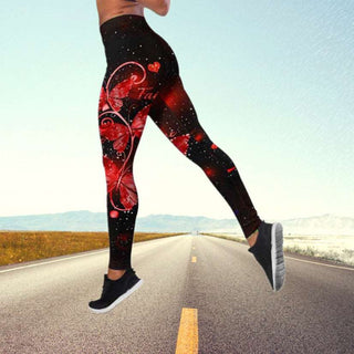 Vibrant butterfly-patterned high-waist yoga pants displayed on a woman's legs standing on a road against a mountain backdrop