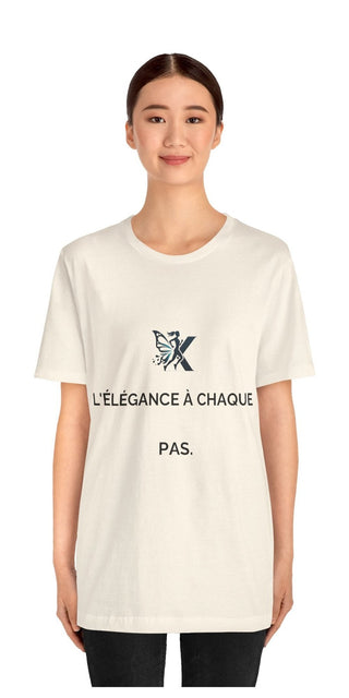 Chic and contemporary unisex white t-shirt with French text graphic design, showcased by a smiling young woman against a plain background.