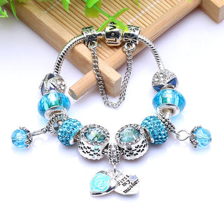 Elegant turquoise beaded bracelet with floral charms and dangling heart pendant, showcasing a stylish Mother's Day gift.