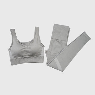 Grey seamless sports bra and matching leggings on gray background