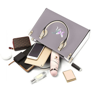 Luxury women's fashion accessories on a gray background. The image shows a leather wallet, makeup items, and other stylish accoutrements typically associated with a fashionable woman's accessories.