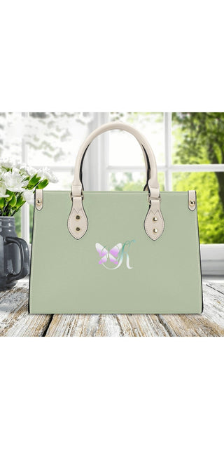Elegant mint green leather handbag with butterfly emblem, stylish silver hardware, and a spacious design for versatile use.