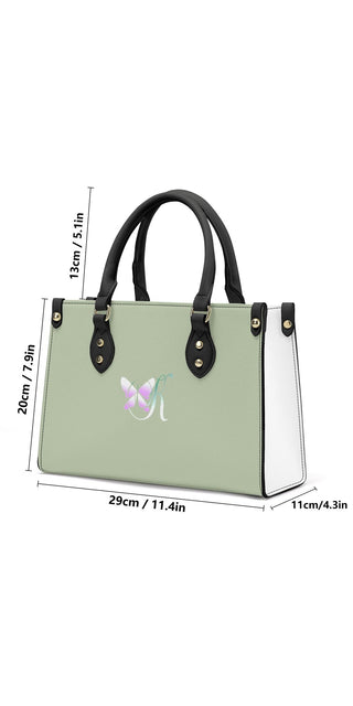 Stylish women's PU leather handbag in mint green color with contrasting black handles, showcased on a white background.