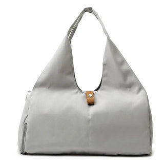 Stylish gray sports duffle bag with leather accents and a zipper closure, suitable for women's fitness, yoga, or weekend travel needs.
