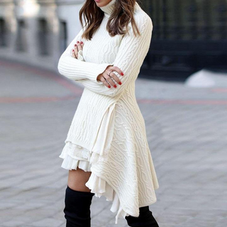 Stylish loose knit dress with ruffle details, worn by a woman with long brown hair in a casual, winter setting.
