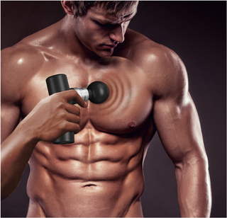 Muscular man using percussion massager to relieve tension and pain in his torso