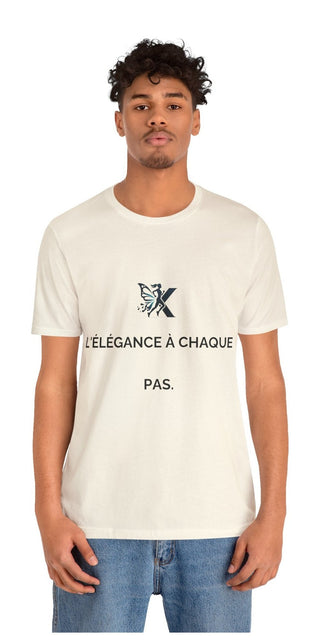 Stylish unisex jersey short sleeve t-shirt with fashionable printed text, "L'élégance à chaque pas" (Elegance with every step) on a model with curly hair against a plain background.