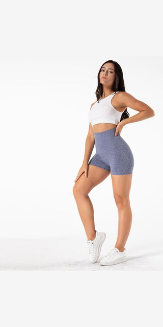 Comfortable yoga shorts for a versatile workout - white sports bra, gray high-waisted shorts, female model in a neutral pose against a plain white background.