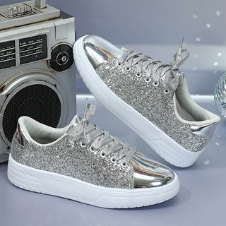 Stylish women's silver glitter sequin sneakers with lace-up design and thick soles, showcased alongside a vintage radio against a snowy background.