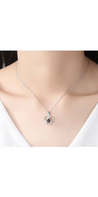 Elegant silver-toned heart-shaped pendant necklace with colorful photo projection, displayed on a female model's neck.