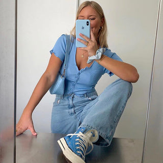 Woman in denim outfit taking a selfie with her smartphone