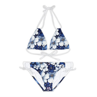 Stylish blue and white floral print bikini set on white background. The image shows a two-piece swimsuit with a triangular top and matching low-rise bottoms featuring a vibrant floral pattern in shades of blue and white.