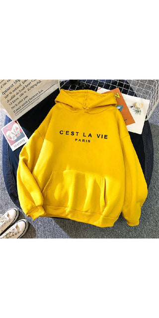 Cozy yellow hoodie with "C'EST LA VIE" printed in black text, suitable for casual wear.