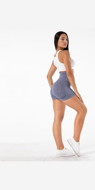 Stylish yoga shorts in a trendy, comfortable design suitable for active lifestyles and all body types. The model is shown wearing the gray shorts and a white top, standing confidently against a plain white background.