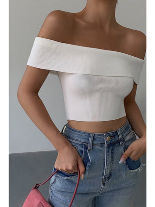 Trendy off-the-shoulder knitted crop top showcased against a plain gray background.