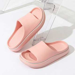 Stylish pink women's slip-on sandals with a modern, minimalist design on a white background.