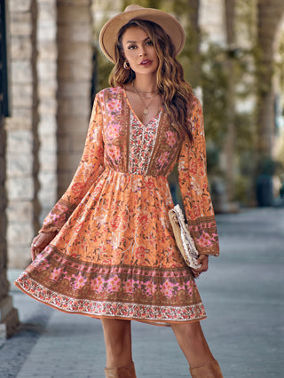 Elegant floral dress with bell sleeves and intricate patterns, worn by a young woman in a natural outdoor setting.
