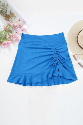Ruched elastic waist blue swim skirt with ruffled hem, ideal for beach or pool wear.
