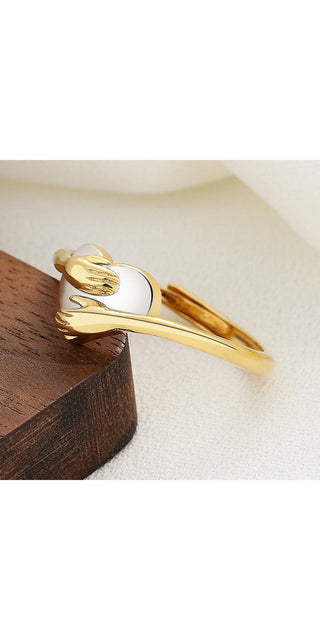 Elegant heart-shaped gold ring on wooden surface, fashionable jewelry accessory from K-AROLE store.