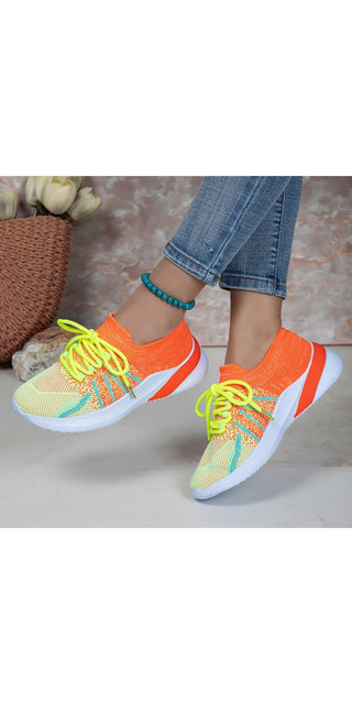 Vibrant mesh sneakers with colorful accents. Lace-up sports shoes with breathable design for comfortable walking or running. Trendy women's casual footwear in eye-catching hues.