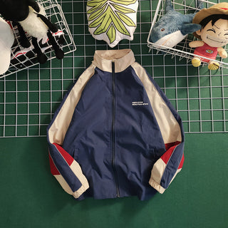 Retro color contrast patchwork baseball jacket with navy blue, beige, and red color blocks on the front and sleeves.