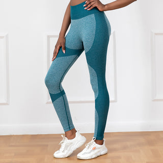 Seamless high-waist teal athletic leggings with sculpting paneling, designed for active lifestyles and paired with white athletic sneakers.