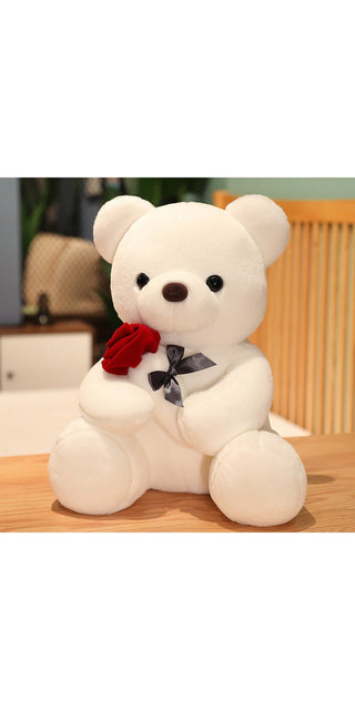 Soft white plush bear toy with red bow tie, sitting on a wooden surface.