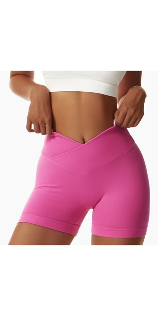 Tight seamless pink sports shorts for women, worn by a female model against a white background.