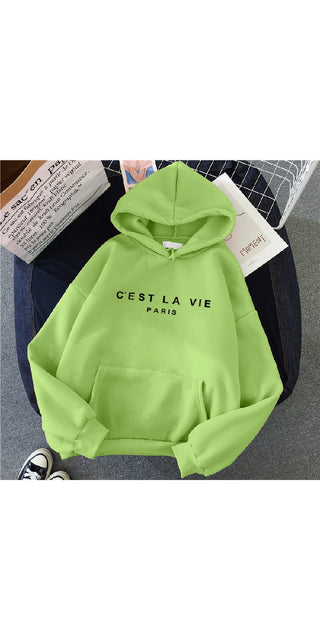 Vibrant green hoodie with "C'EST LA VIE PARIS" printed on the front. The hoodie is placed on a textured surface, creating an eye-catching contrast. The minimalist design and bold color make this a stylish and trendy sports top.