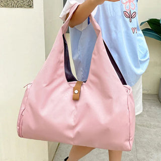 Stylish pink nylon duffle bag with leather details, suitable for yoga, sports, fitness, and travel
