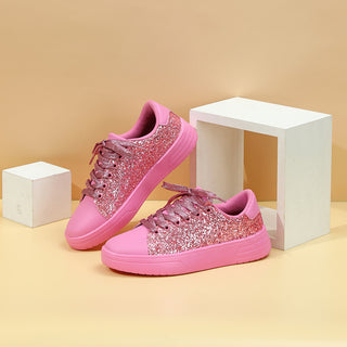 Glittering pink sneakers with sequins and lace-up design on display with minimal white blocks