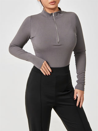 Gray long-sleeved seamless slimming jumpsuit for women, featuring a high neckline and zippered front closure.