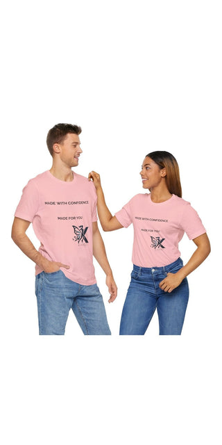 Stylish pink unisex jersey short sleeve t-shirts with monochrome illustrated character prints, worn by a smiling young couple posing together.