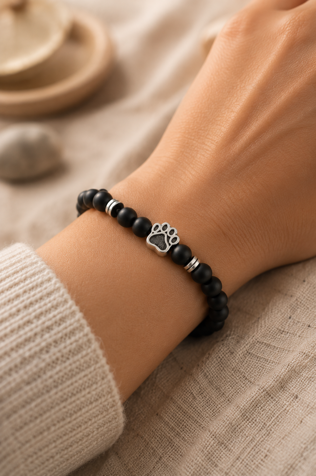 Bracelet Empreinte de Patte K-AROLE porté au poignet, charm empreinte argentée sur perles en pierre naturelle