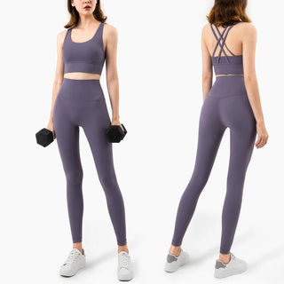 Stylish women's fitness leggings and crop top, featuring a sleek gray design with criss-cross back details, perfect for an active lifestyle.