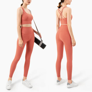 Vibrant coral-colored women's fitness leggings and sports bra from K-AROLE, featuring a stylish criss-cross back design and sleek, form-fitting silhouette for a confident, active look.