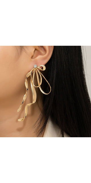 Irregular large bow earrings with tassel streamer for women, elegant jewelry accessory in metallic finish.