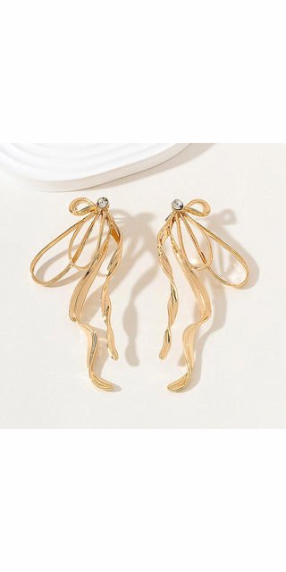 Elegant tassel earrings with a large golden bow and dangling streamer accents, showcased on a white background.