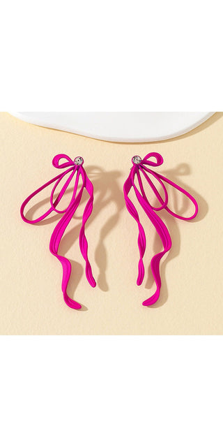 Captivating pink tassel earrings with irregular large bows on a pale beige background.