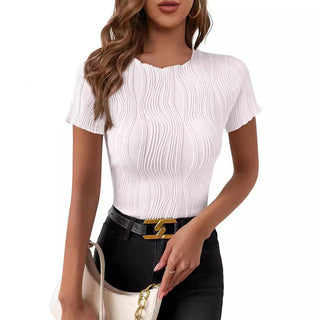Stylish white short-sleeved top with a pleated pattern, worn by an elegant model with long wavy hair.