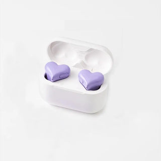 Stylish heart-shaped wireless Bluetooth earphones in a sleek white charging case. The lavender-colored earphones feature a modern, fashionable design perfect as a gift for the trendy woman.