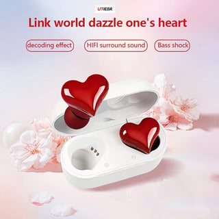 Heart-shaped wireless earphones with noise reduction feature, presented in a stylish white charging case and surrounded by delicate pink flowers, offering a captivating audio experience.
