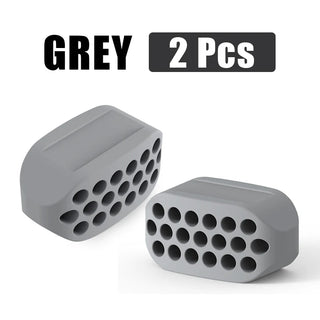Pair of grey silicone jaw exerciser facial toning tools with perforated design for facial muscle fitness and defined jawline.