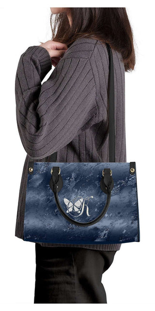 Stylish K-AROLE handbag tote in chic blue marble pattern, held by a fashionable woman in a cozy grey sweater.