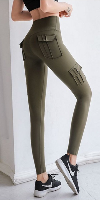 Stylish olive green cargo leggings with pockets, worn with sneakers, against a plain white background.
