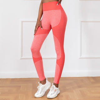 Stylish coral-colored stretchy yoga pants with trendy seamless design, featuring a high-waisted silhouette and lifting effect to flatter the figure. Paired with modern white sneakers, the image showcases a fashionable and activewear-inspired look.