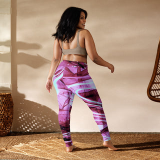 Vibrant pink and purple patterned yoga leggings displayed on model against warm-toned background