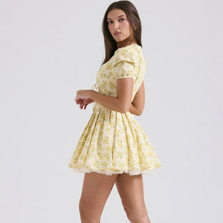 Yellow floral v-neck puff sleeve dress worn by woman against plain white background